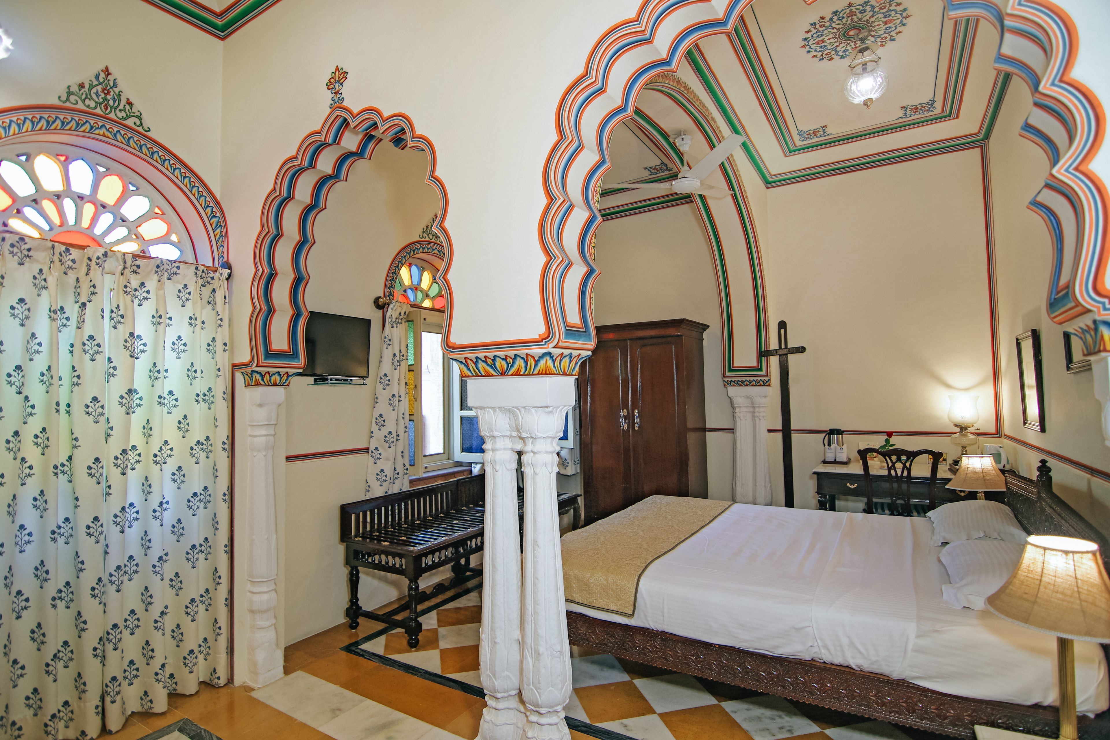 Ein traditionell eingerichtetes Zimmer mit einem Bett, einem Schreibtisch und einem Sessel.