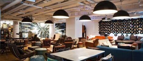 A modern interior with exposed ceilings, industrial lighting, and a wall of vinyl records.