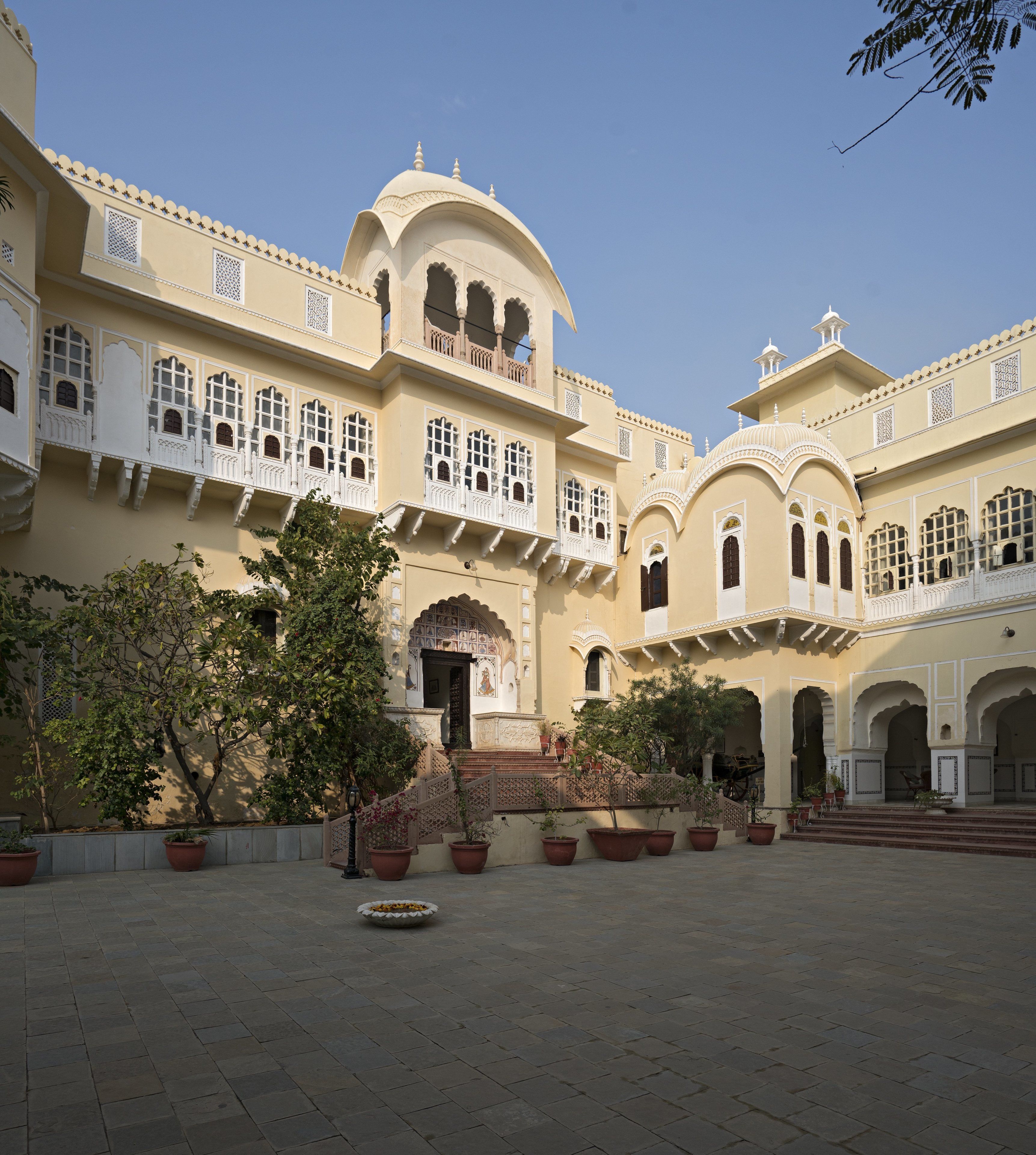 A traditional building with multiple arches and a central staircase leading to a balcony.