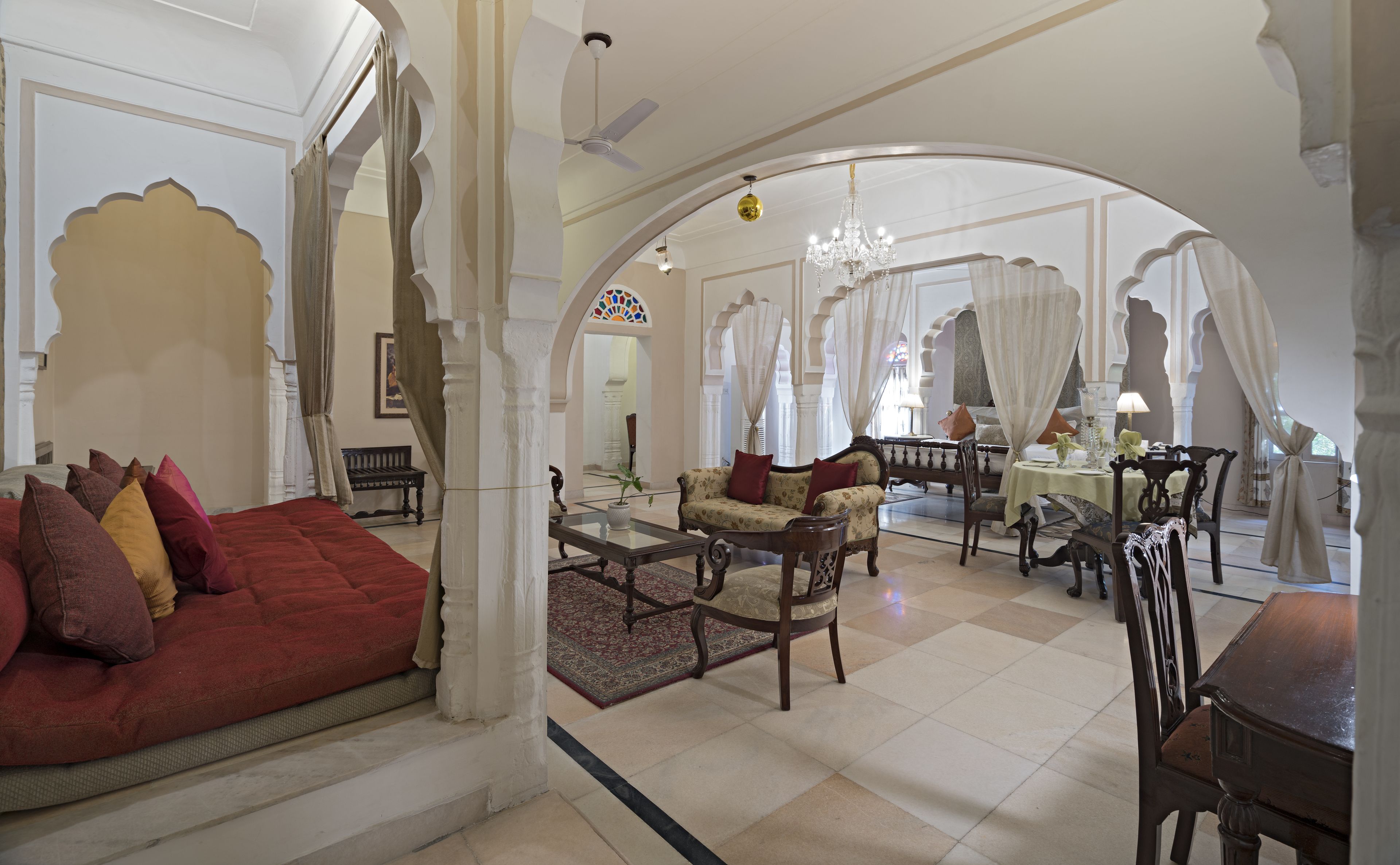 Un interior tradicional con un sofá rojo, muebles de madera y una araña.