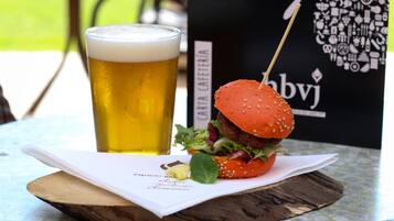 Een maaltijd bestaande uit een hamburger en een glas bier op een tafel met een menukaart.