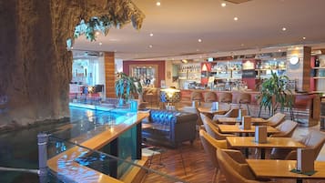 Un espace bar avec des sièges et une table de billard.