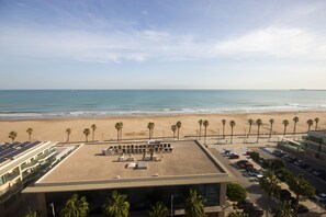 A beachside hotel with a rooftop pool, beach access, and a parking area.