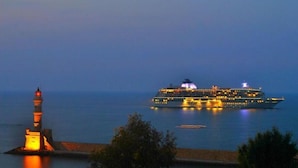 Un crucero de noche con un faro al frente.