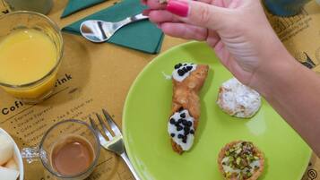 Una tavola imbandita con prodotti per la colazione, tra cui pane tostato, pasticcini e una ciotola di frutta.