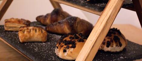 A wooden stand with three tiers holding pastries.
