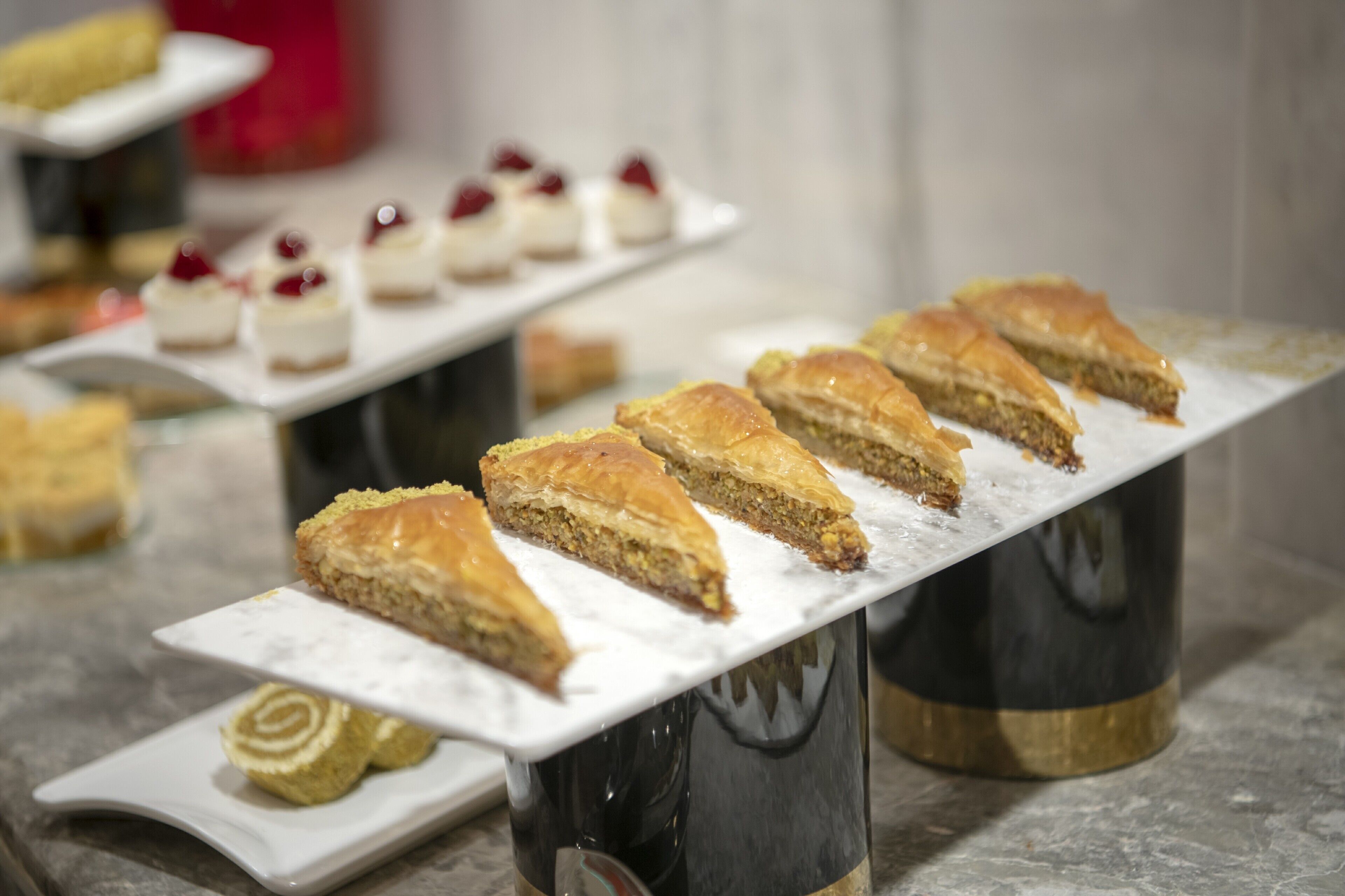 A dessert display with various pastries on a marble countertop.