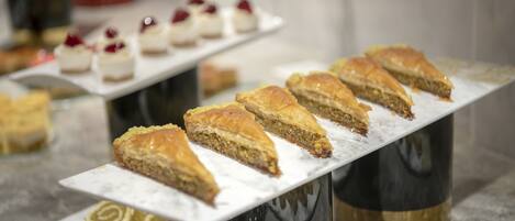 A dessert display with various pastries on a marble countertop.
