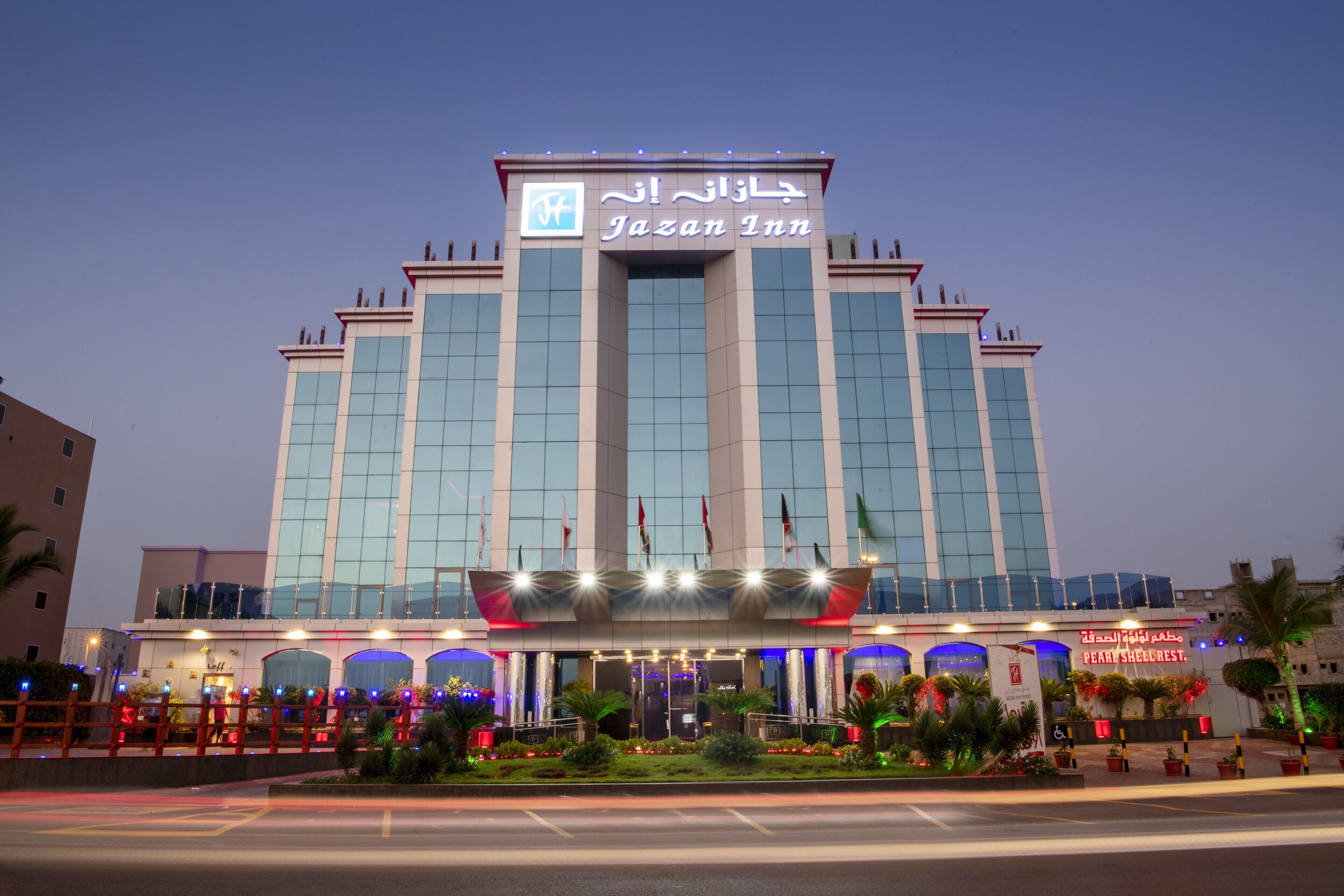 A large hotel building with a prominent sign reading "Jazan Inn".