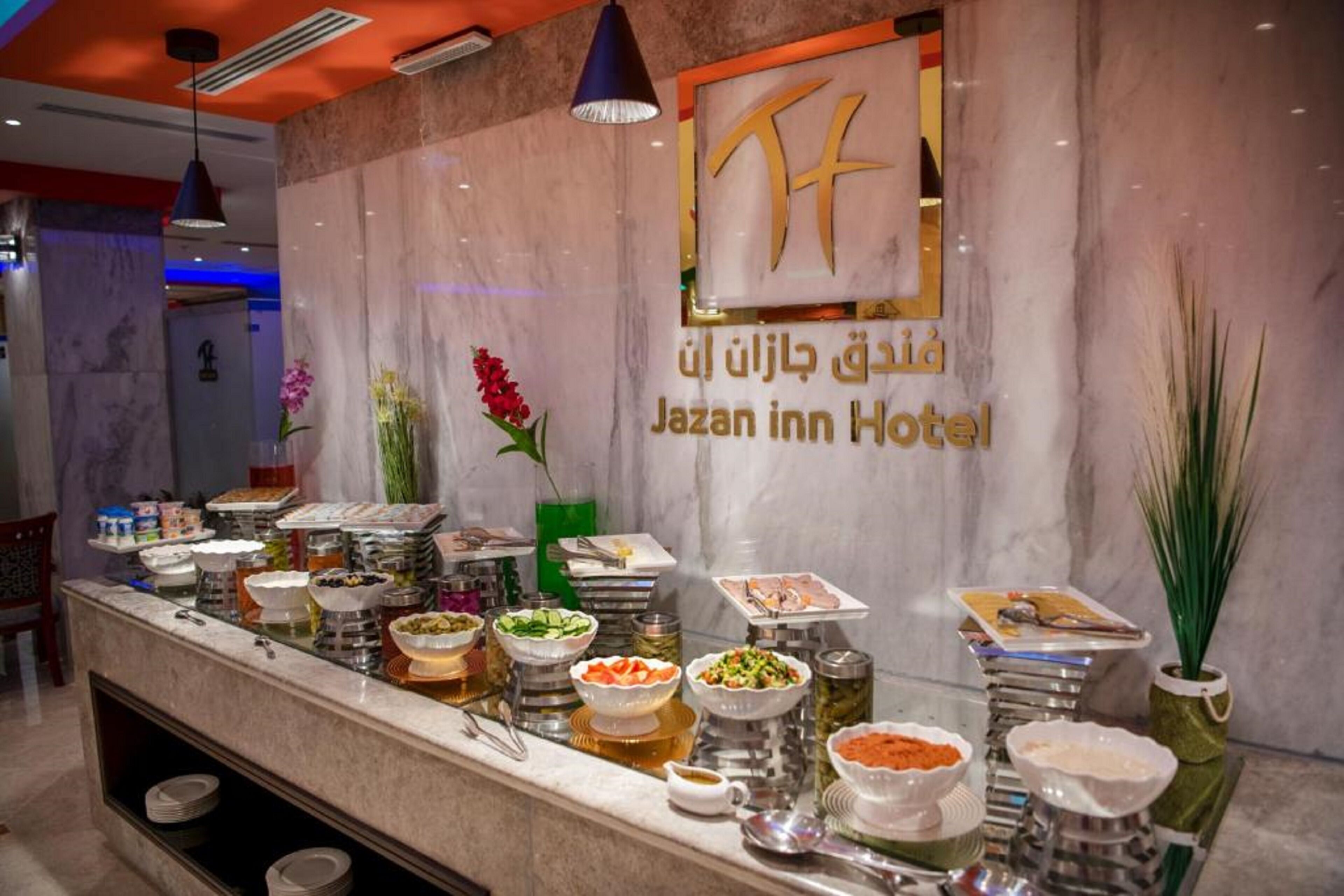 Montaje de bufé en el Hotel Jazan Inn con diversos alimentos y condimentos.