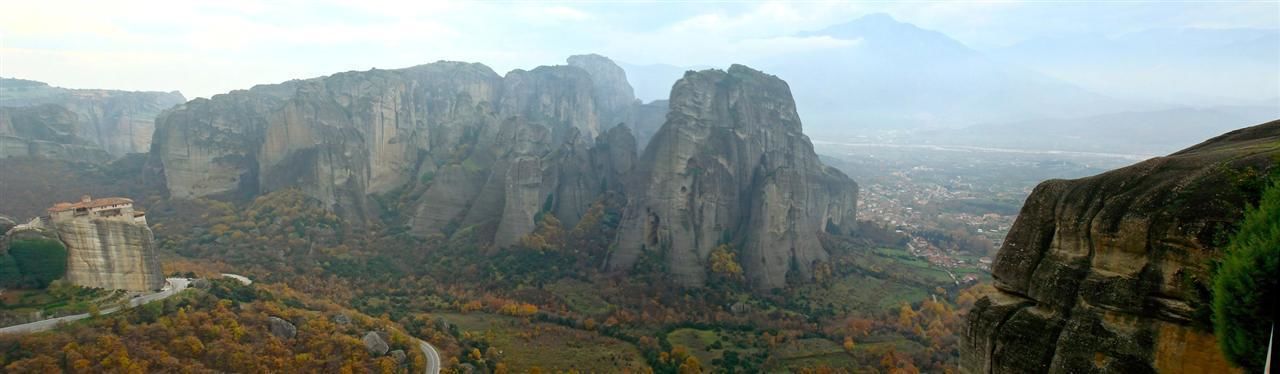 A mountainous landscape with prominent rock formations and a winding road.