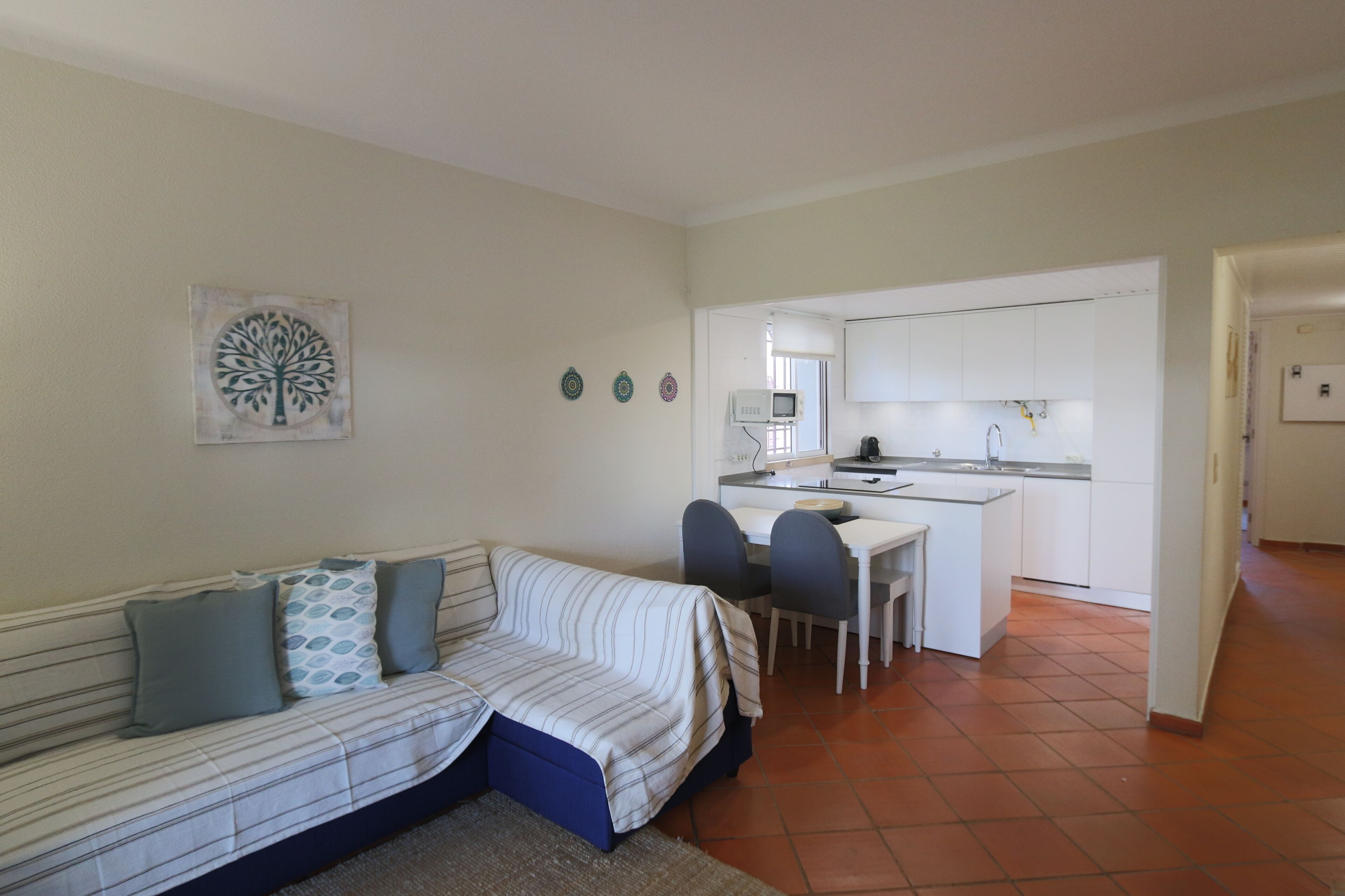 A compact living space with a sofa, a small dining table, and a kitchenette.