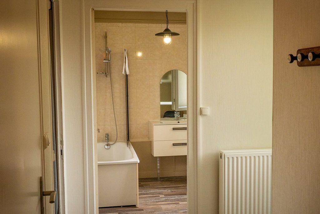 Une salle de bain avec une baignoire, une douche, un lavabo et un miroir.