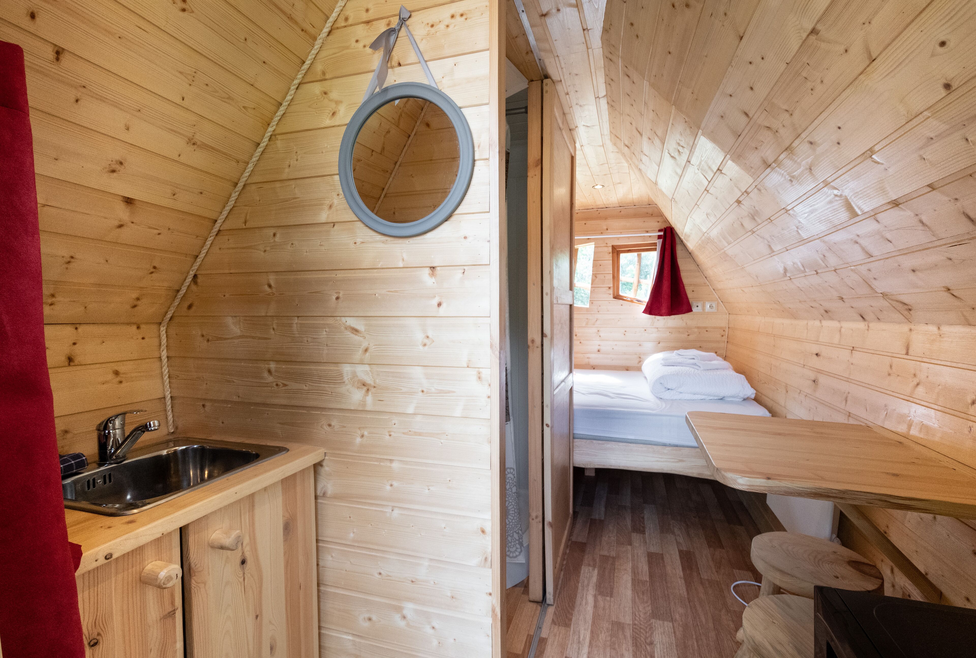 L’intérieur d’une cabane en bois comprend un coin cuisine, un lit et une petite salle de bain.