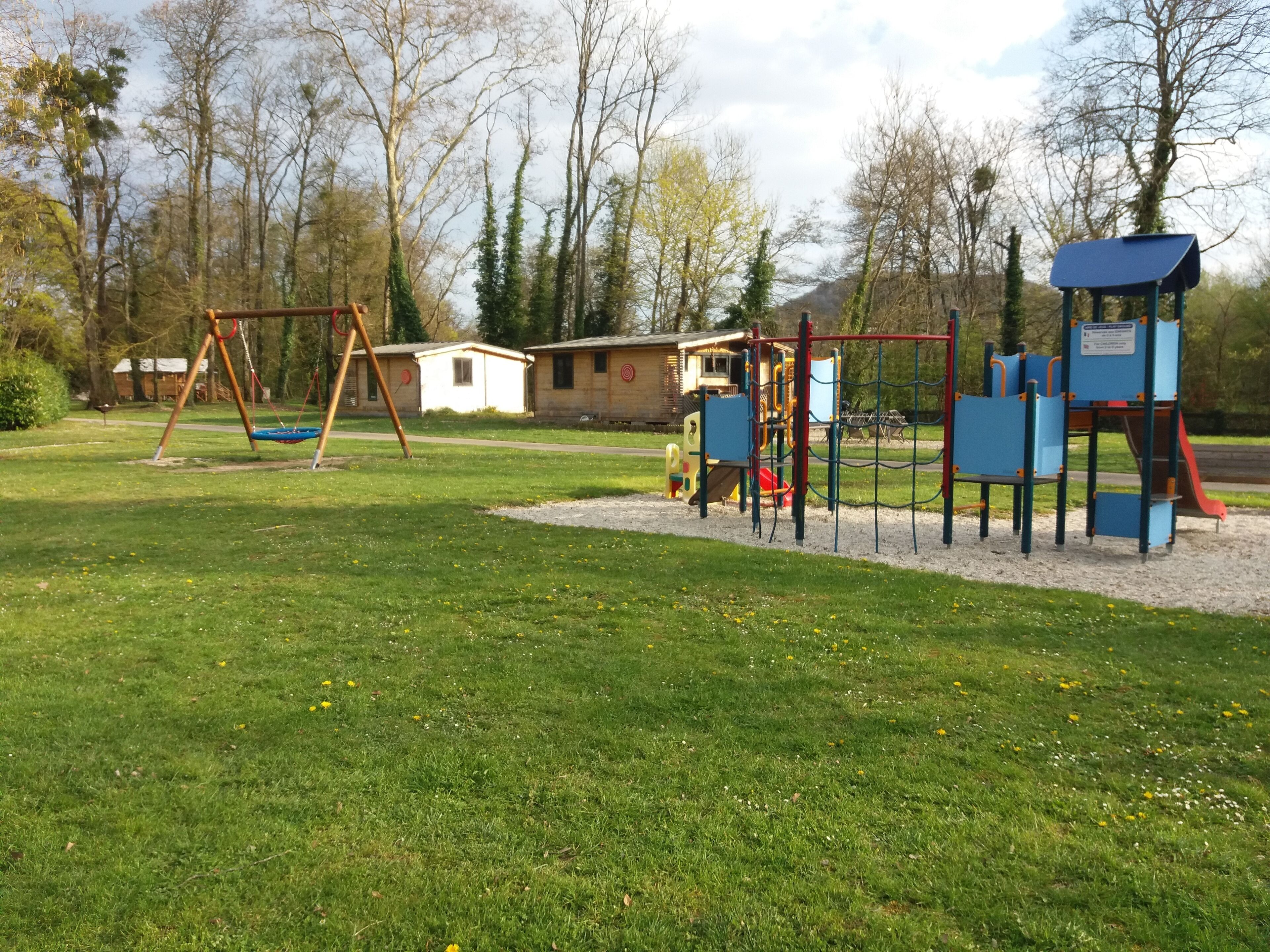 Un parque infantil con columpios, toboganes y estructuras para escalar.