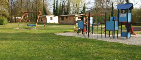 Un parque infantil con columpios, toboganes y estructuras para escalar.
