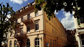 A historic building with a balcony, arched windows, and a sign indicating it is a hotel. - Hotel Römerhof (Baden-Baden)