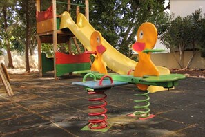 Un patio de recreo con un balancín y un tobogán.