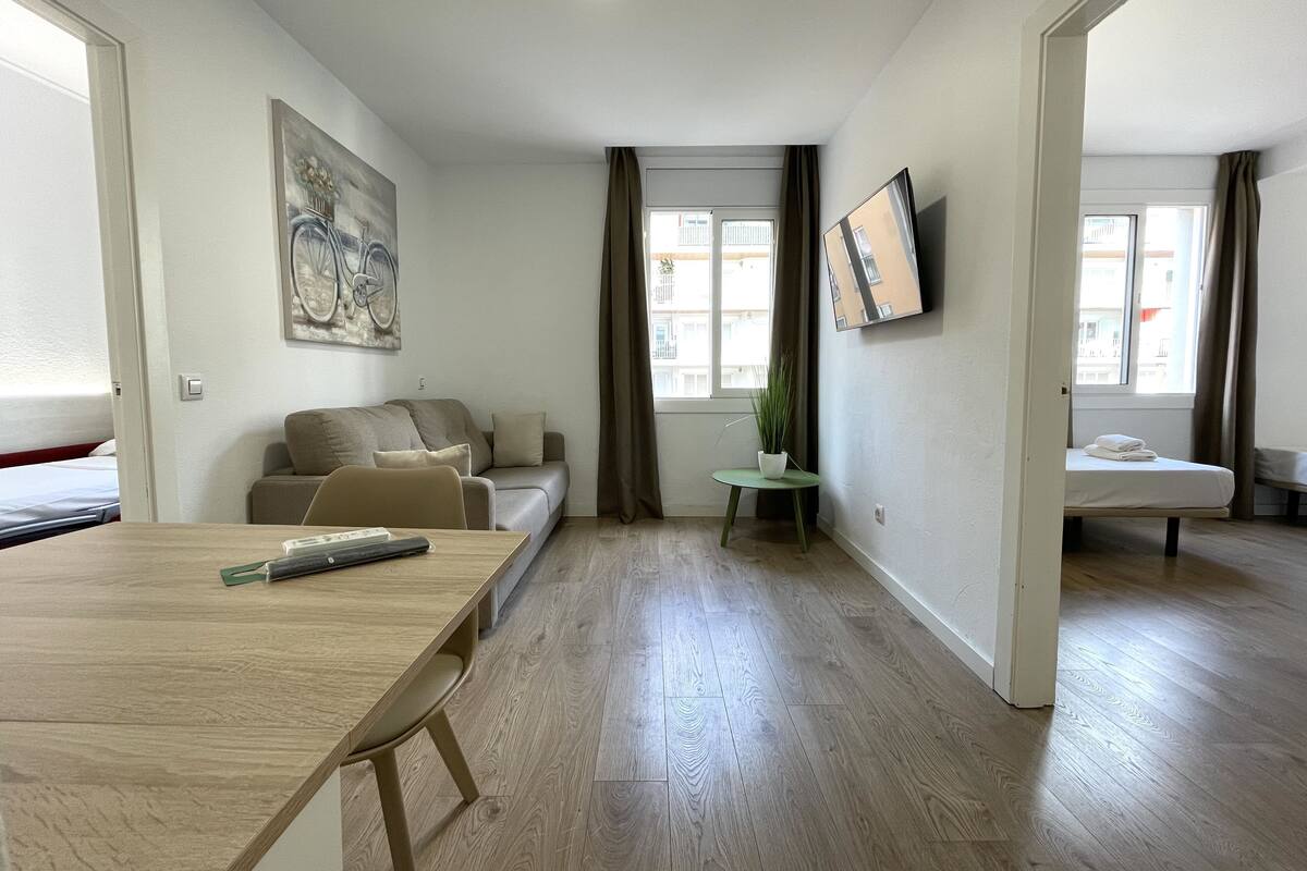 Een moderne woonkamer met een bank, een eettafel en een bijzettafeltje met een plant.