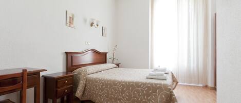 Escritorio, cortinas blackout y tabla de planchar con plancha