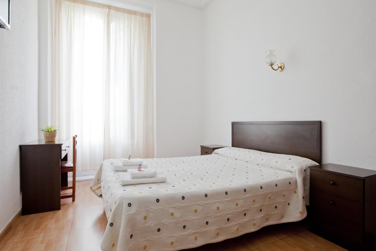 Escritorio, cortinas blackout y tabla de planchar con plancha