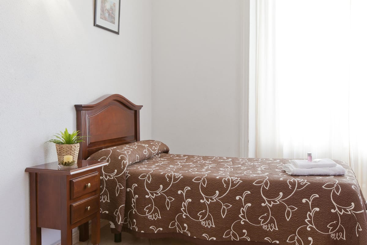 Escritorio, cortinas blackout y tabla de planchar con plancha