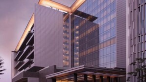 Um edifício moderno com fachada de vidro marcante e um design angular único.