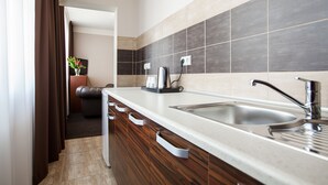 Una cocina moderna con un lavamanos de acero inoxidable, armarios de madera y un protector contra salpicaduras de azulejos.