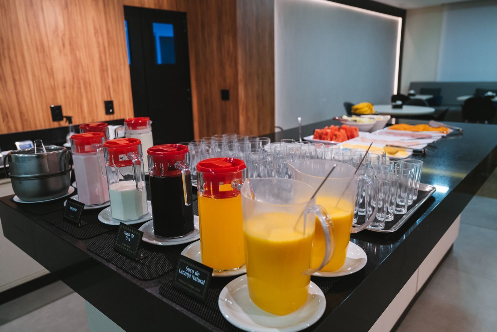 A buffet with various beverages and a fruit platter.