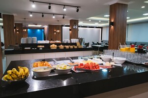 Un bufé con diversas frutas, verduras y bebidas.