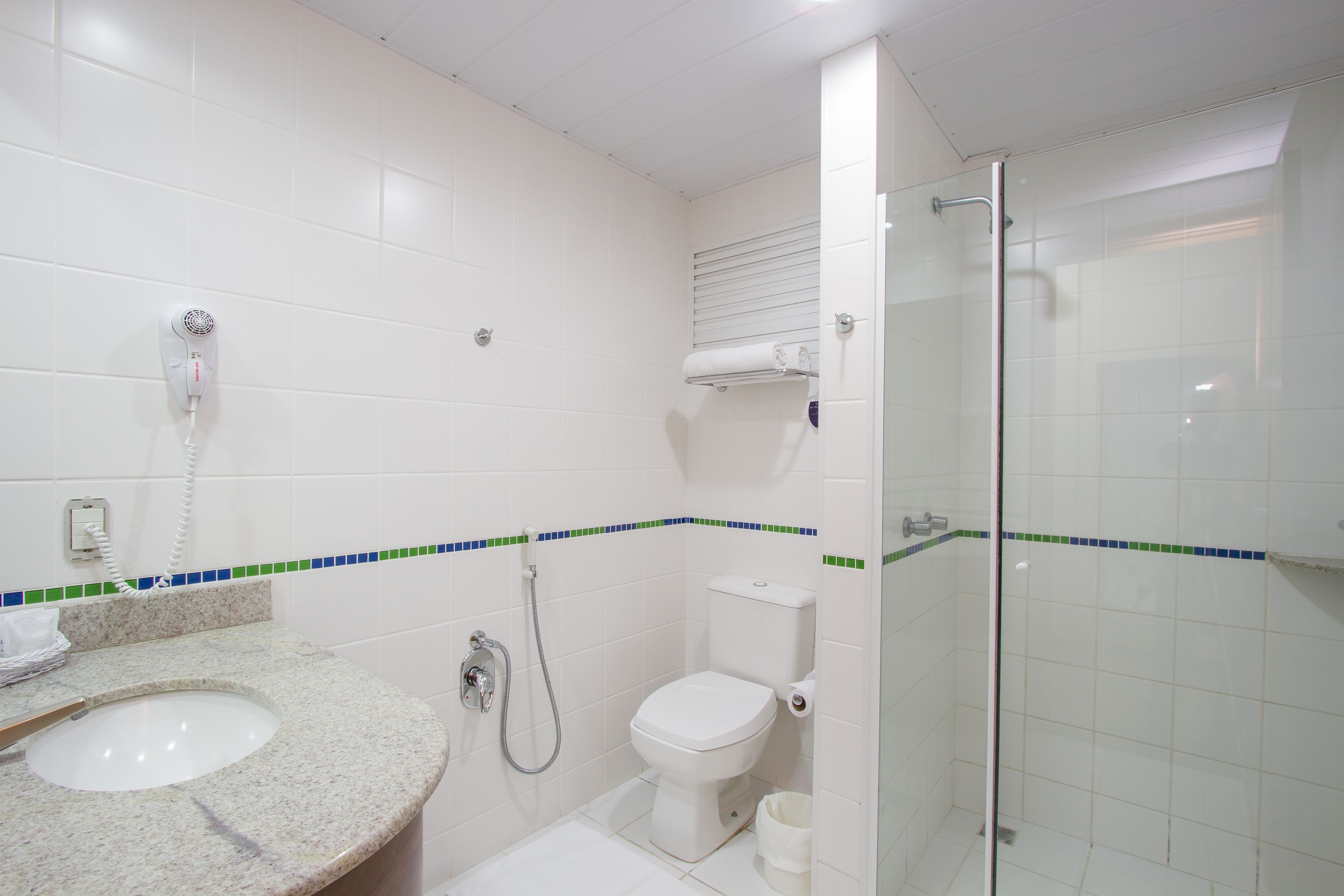 A bathroom with a sink, toilet, and glass-enclosed shower.