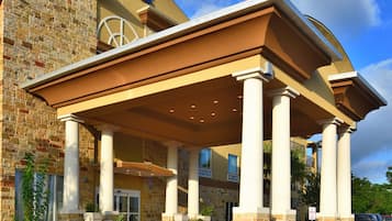 Welcome to Holiday Inn Express, featuring a stone facade and a covered entrance with white columns.