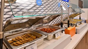 A buffet with labeled trays of turkey sausage and cookies. - Holiday Inn Express & Suites Fredericksburg by IHG (Fredericksburg)