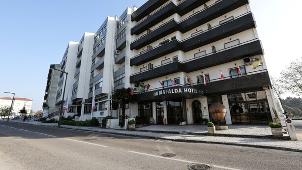 Un hotel de varios pisos con balcones y una entrada destacada.