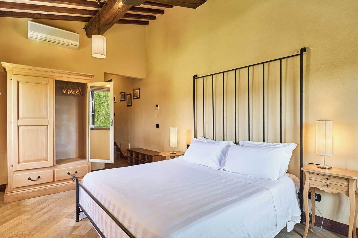Une chambre à coucher comprenant un lit, des tables de chevet, une armoire et un bureau.
