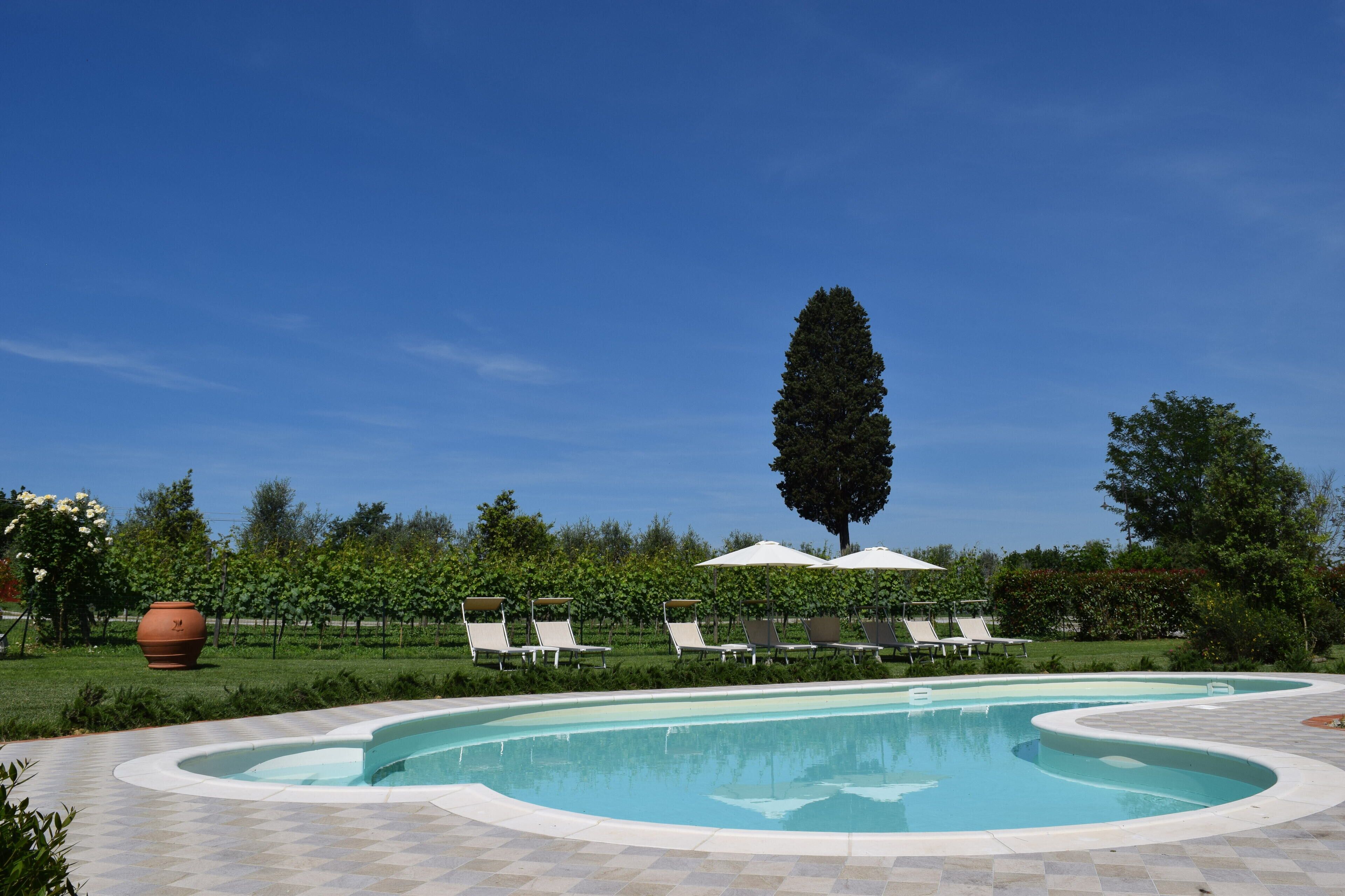 Utendørsbasseng og solsenger