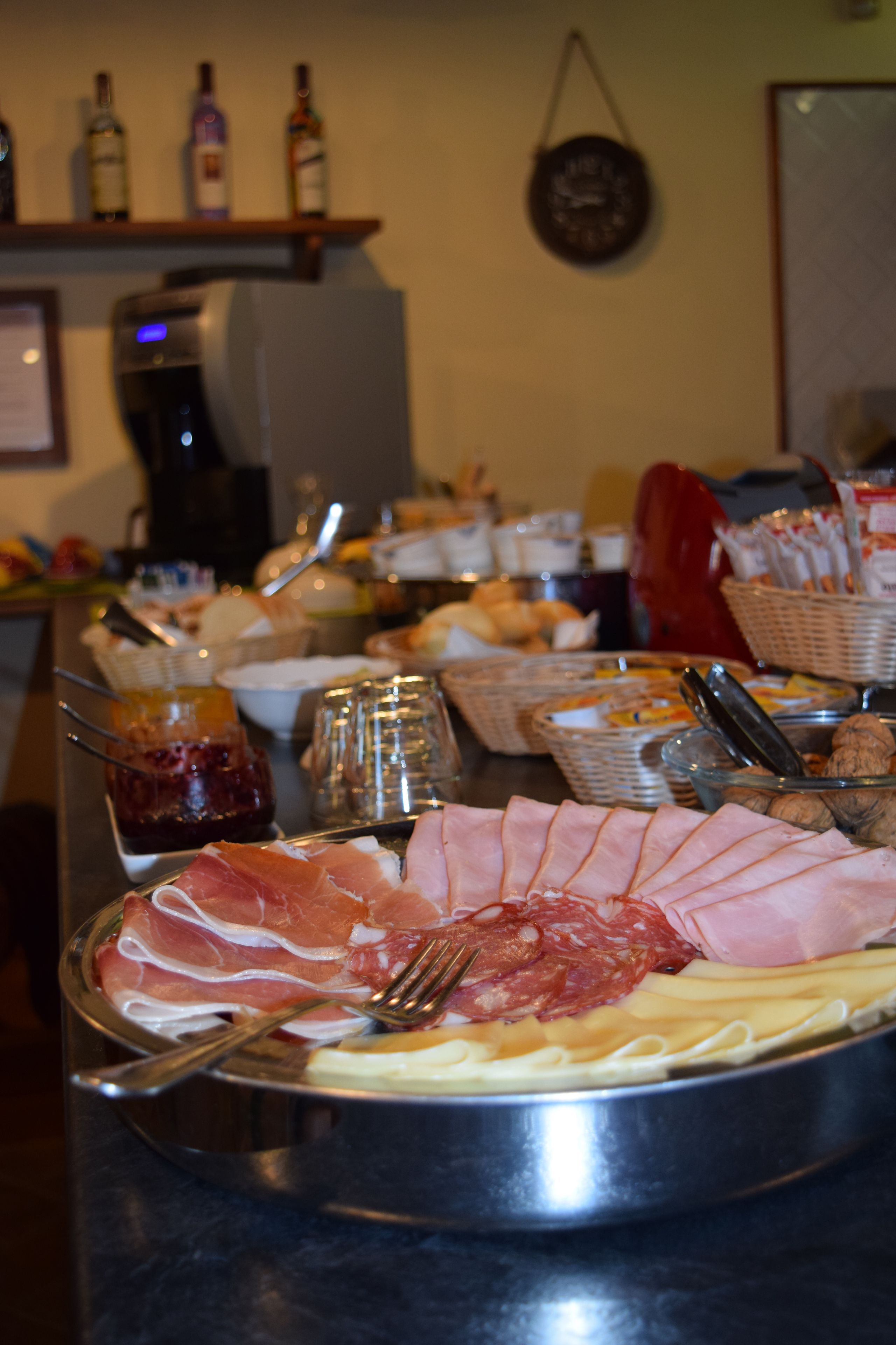 Un bufé con una variedad de alimentos, incluyendo carnes, quesos y salsas.