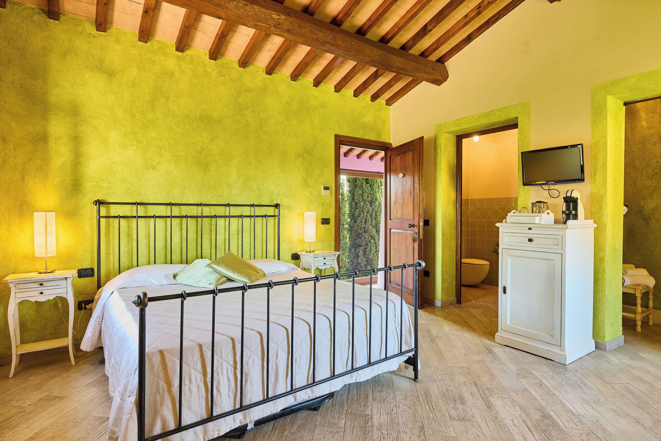 Ein Schlafzimmer mit Bett, Nachttischen, Fernseher und Schrank.