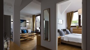 Een moderne hotelkamer met een groot bed, een zithoek met een ronde tafel en een grote spiegel.