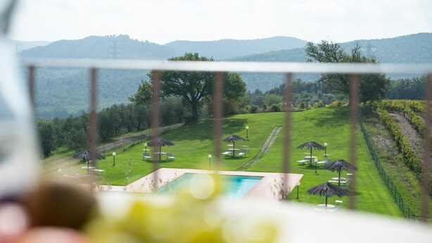 A pool area with a view of a lush green landscape and distant hills. - Agriturismo Poggio Corbello (Massa Marittima)