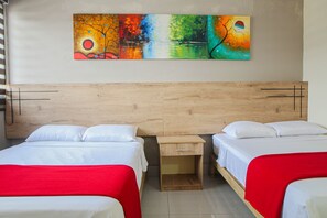 A hotel room with two beds, a wooden headboard, and a wall-mounted painting. - Murali Hostal Guayaquil (Guayaquil)