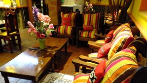 Una sala de estar acogedora con sofás a rayas, una mesa de centro de madera y un jarrón con flores.