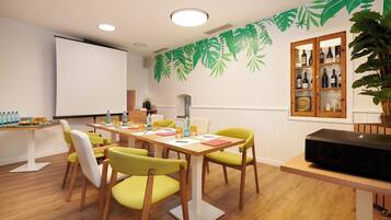 A conference room with a whiteboard, a projector, and a cabinet with bottles.
