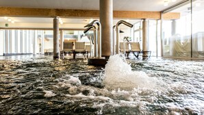 Un área de hidromasaje con fuente de agua, asientos y diseño de interiores moderno.