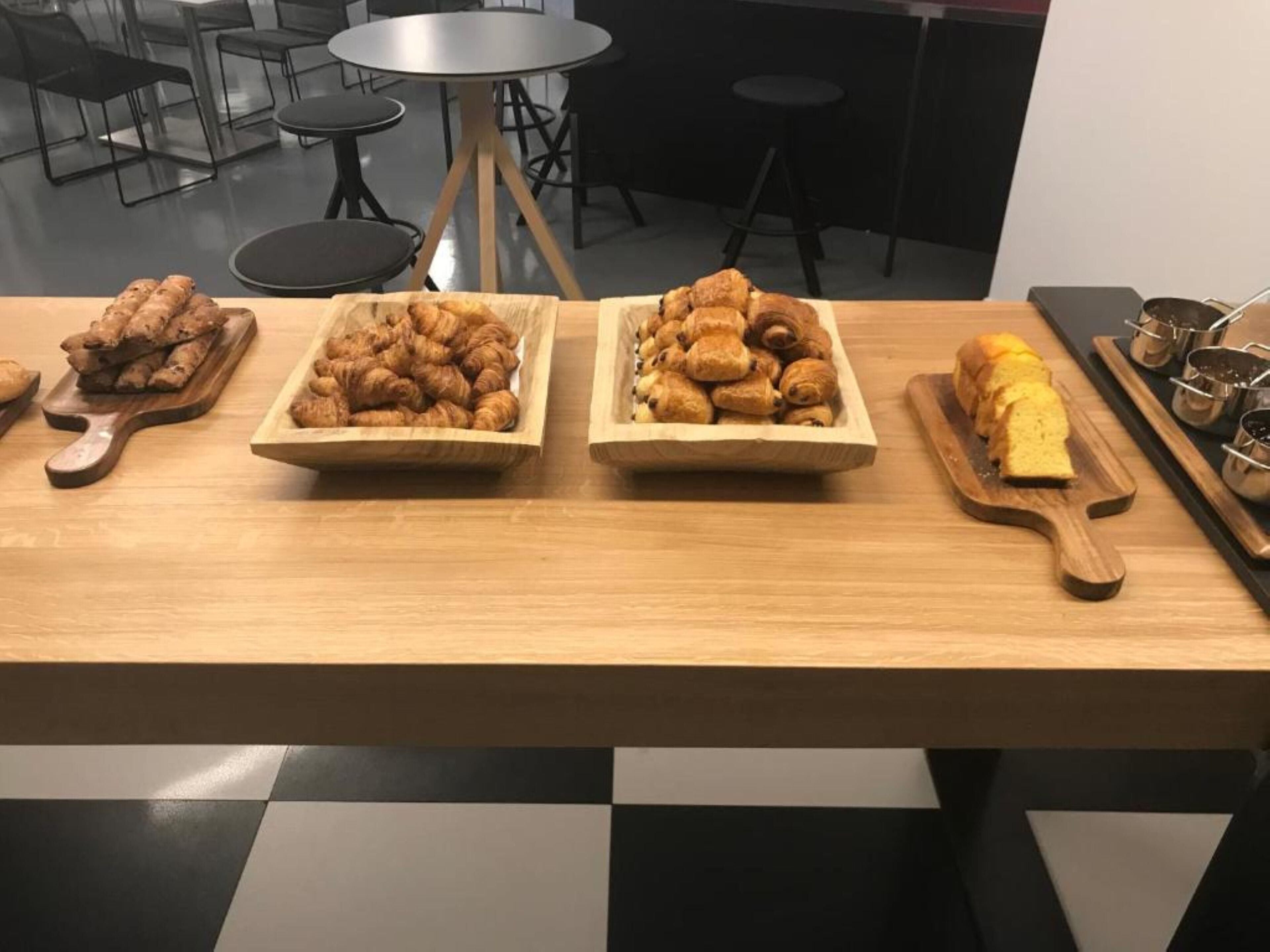 Ein Holztisch mit drei Holztabletts, die mit Gebäck belegt sind.