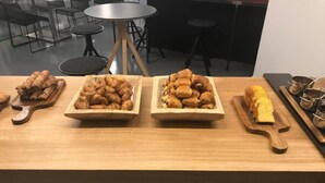 A wooden table with three wooden serving trays containing pastries. - Enzo Trappes by Kyriad Direct (Trappes)