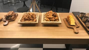 Ein Holztisch mit drei Holztabletts, die mit Gebäck belegt sind.