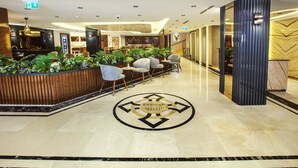 A hotel lobby with a reception desk, seating area, and a decorative floor pattern. - Endican Beyazit Hotel (Istanbul)