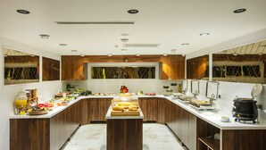 A modern kitchen with a marble countertop, wooden cabinets, and a central island with food items. - Endican Beyazit Hotel (Istanbul)