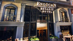 The exterior of the Endican Beyazit Hotel with classical architecture, large windows, and ornate balcony railings. - Endican Beyazit Hotel (Istanbul)